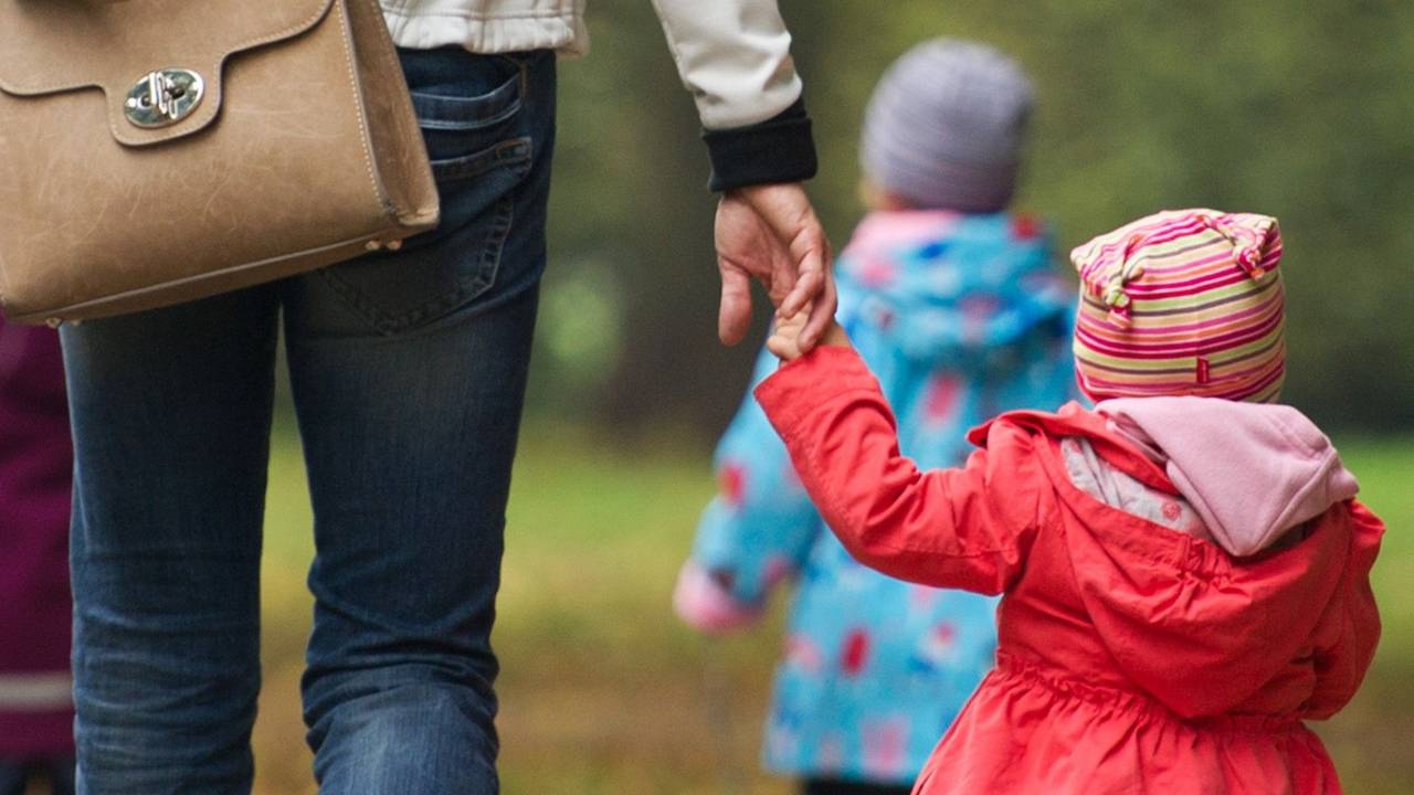 Eine Frau geht mit Kindern im Wald spazieren.