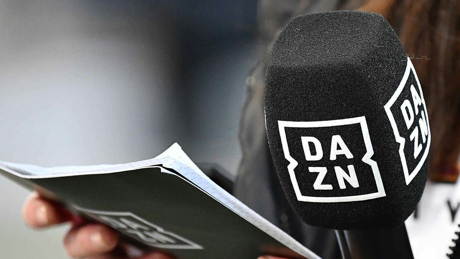 Ein Mikrofon und Moderationskarten mit dem DAZN-Logo bei einer Bundesliga-Übertragung