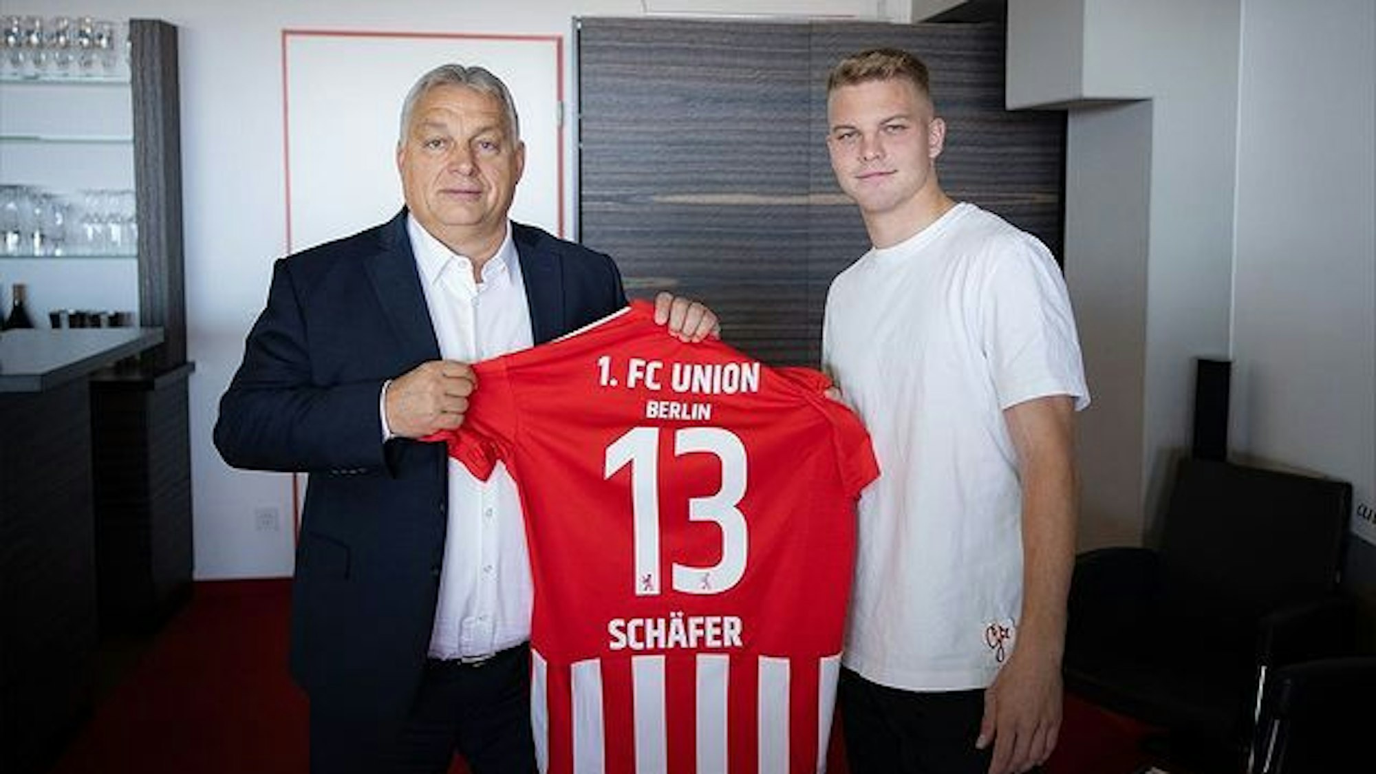 Ungarns Ministerpräsident Viktor Orbán posiert auf einem Foto in den Räumlichkeiten des Stadions an der Alten Försterei mit Union Berlins ungarischem Spieler András Schäfer.