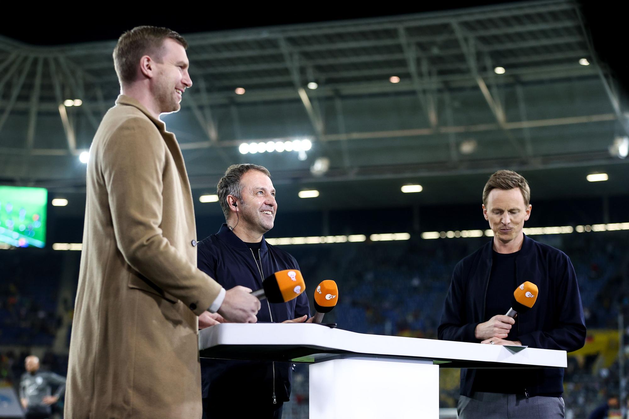 Deutschlands Trainer Hans-Dieter Flick (M.) im Interview mit dem ehemaligen Nationalspieler Per Mertesacker (l.) und TV-Moderator Jochen Breyer vom ZDF.