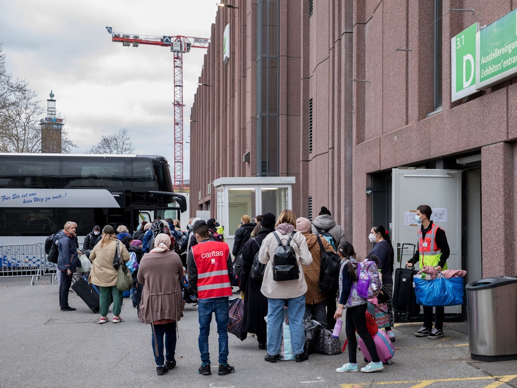 Geflüchtete Menschen stehen vor dem Eingang der Koelnmesse. Dort werden die Menschen zeitweise untergebracht.