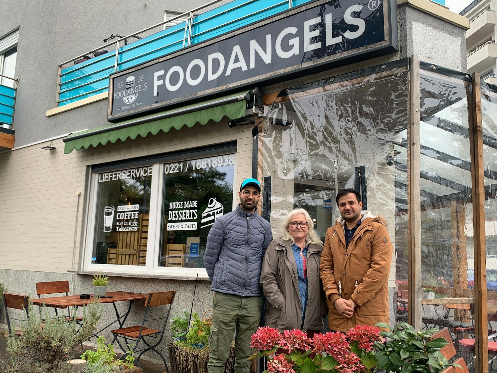 Zwei Männer und eine Frau stehen vor dem Bistro Foodangels.