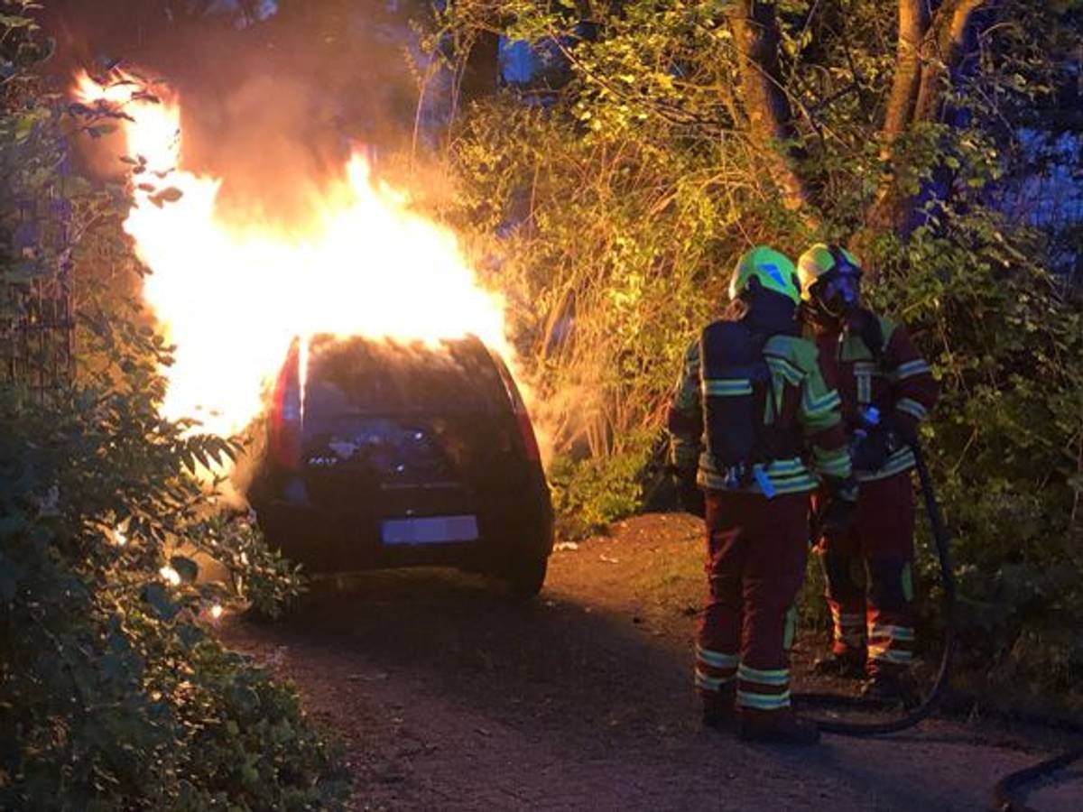 Die Feuerwehr löscht ein brennendes Auto.