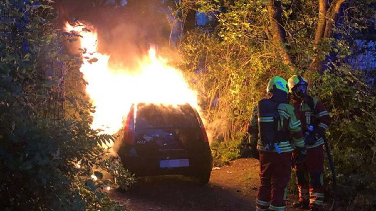 Die Feuerwehr löscht ein brennendes Auto.