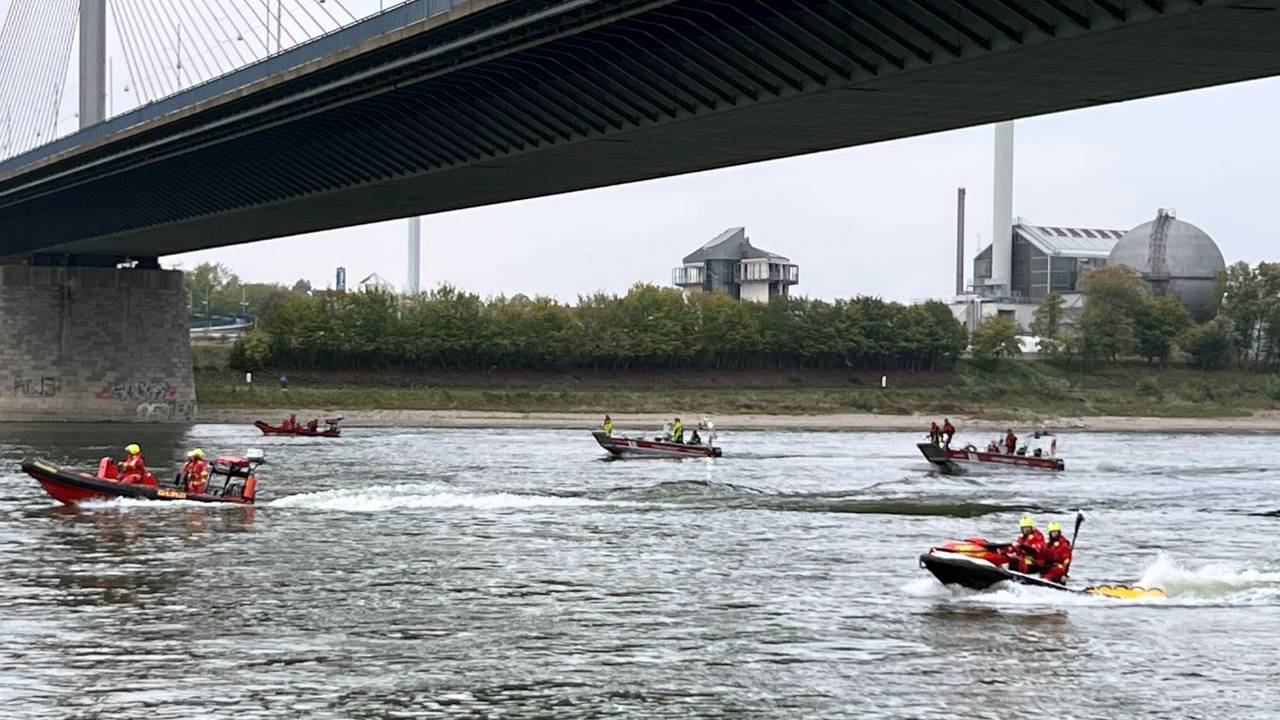 Einsatzkräfte fahren den Rhein mit Booten ab.