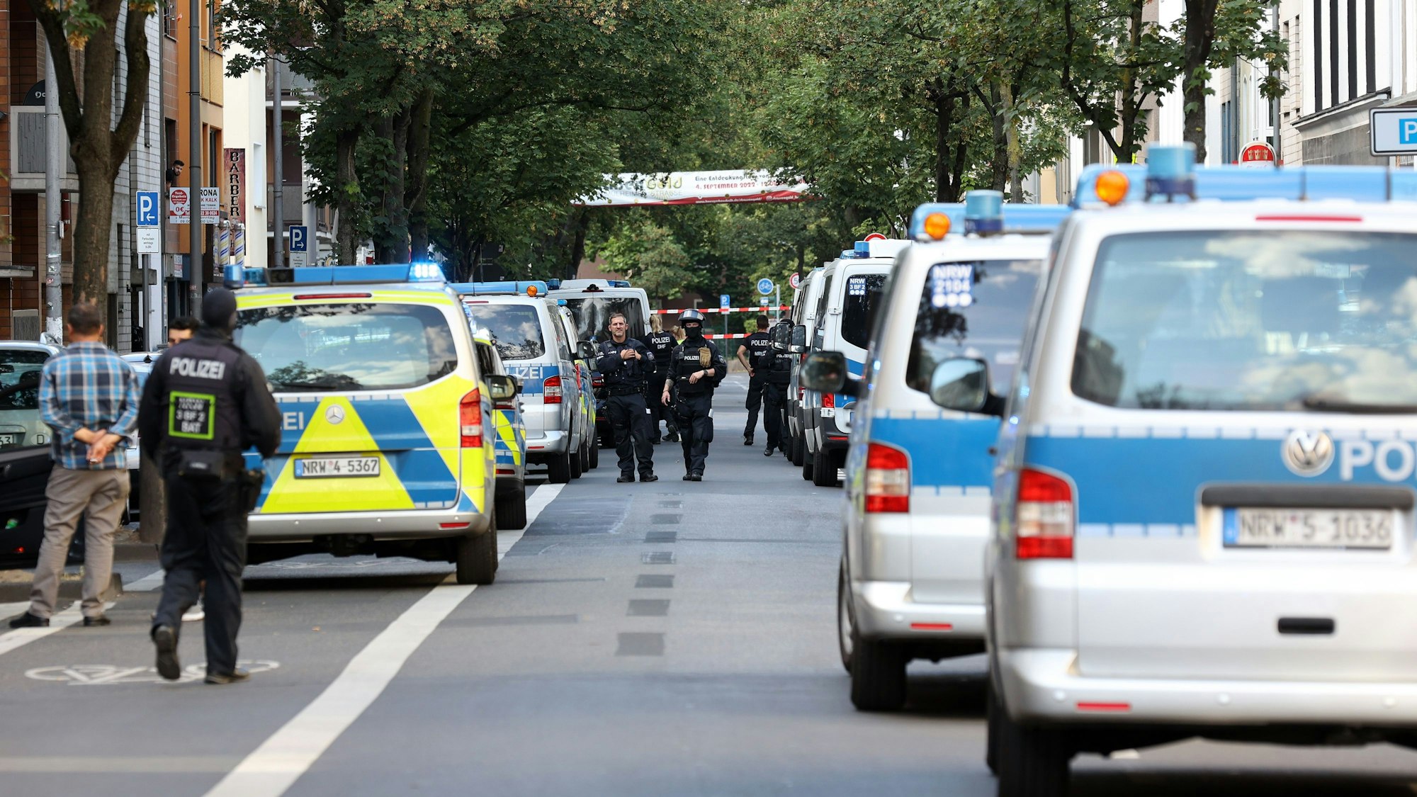 Viele Polizeiautos am Straßenrand bei einer Razzia im Kölner Veedel Kalk.