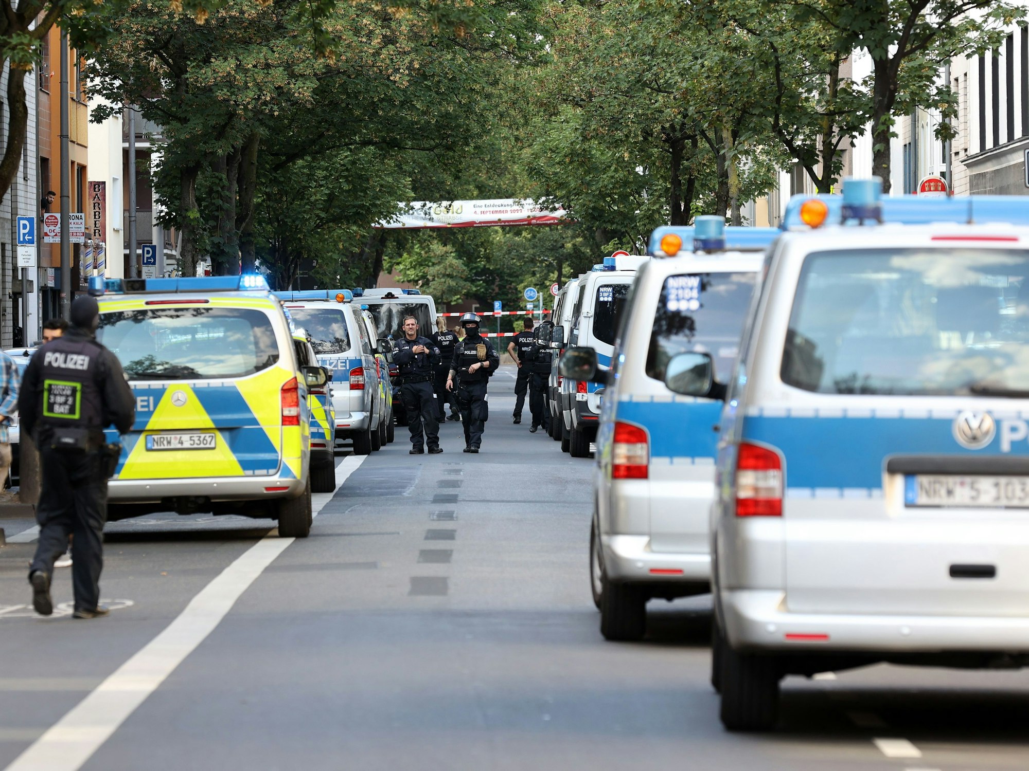Viele Polizeiautos am Straßenrand bei einer Razzia im Kölner Veedel Kalk.