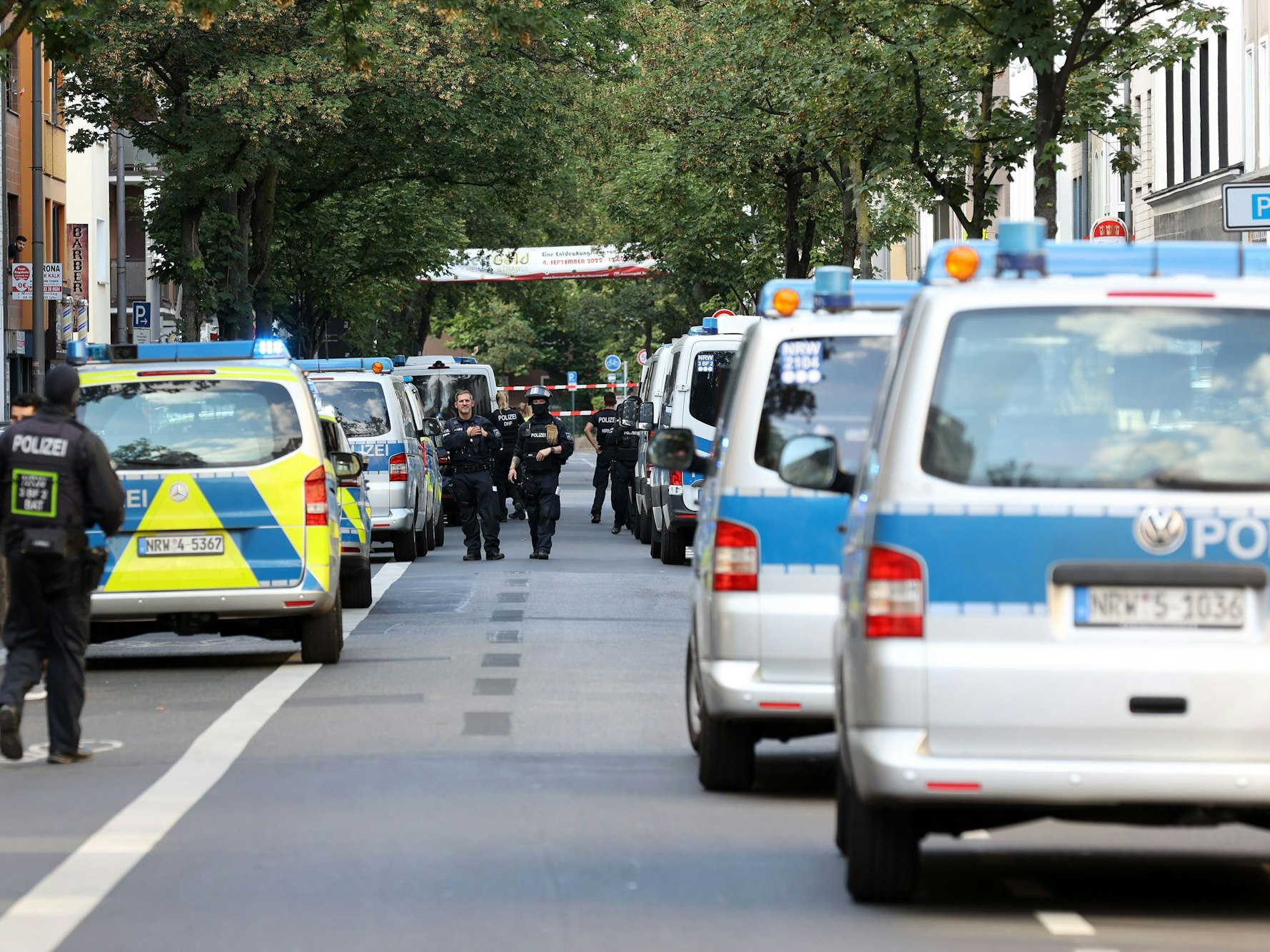 Viele Polizeiautos am Straßenrand bei einer Razzia im Kölner Veedel Kalk.