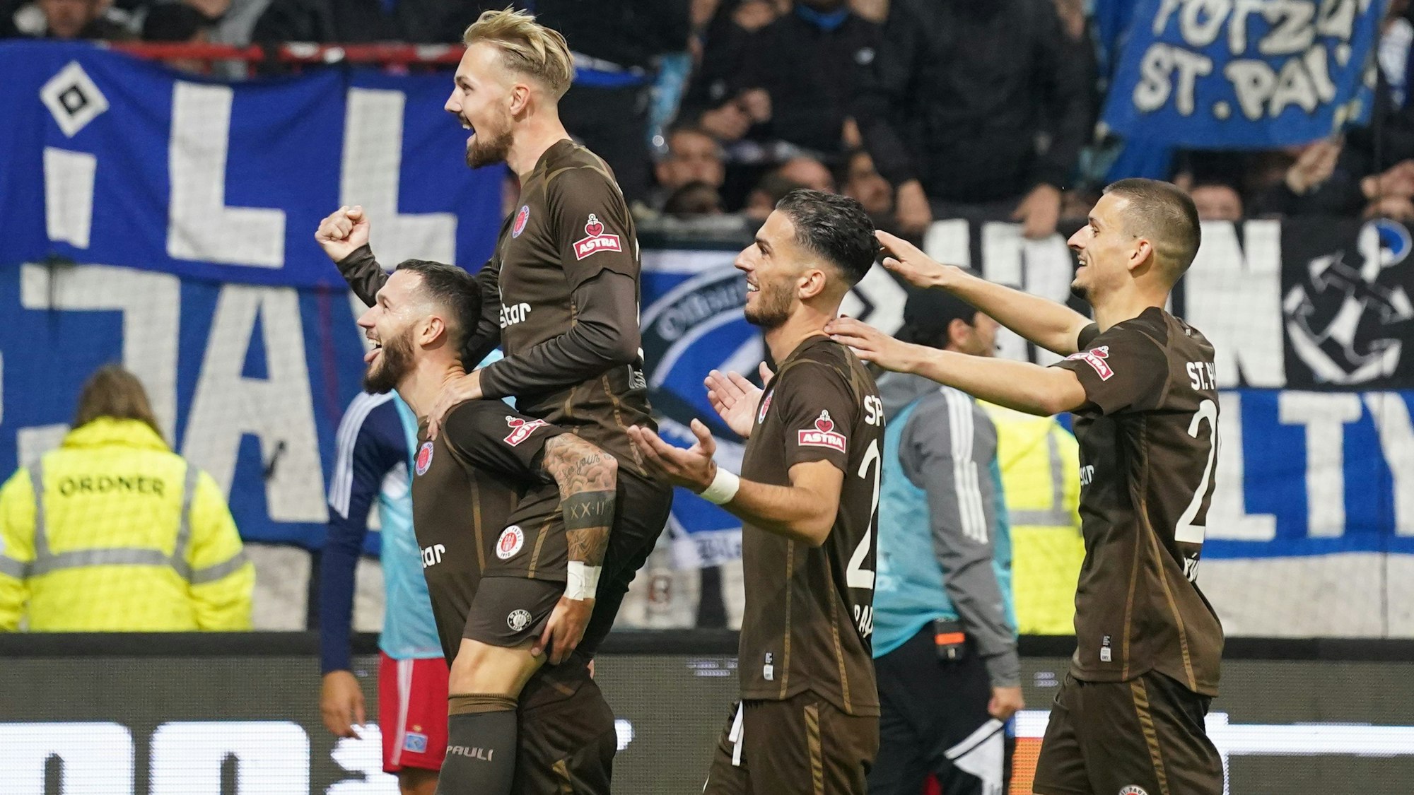 Die Spieler des FC St. Pauli (von links) Marcel Hartel, Lukas Daschner, Leart Paqarada und Adam Dzwigala feiern das Tor zum 2:0 gegen den Hamburger SV am 14. Oktober 2022.