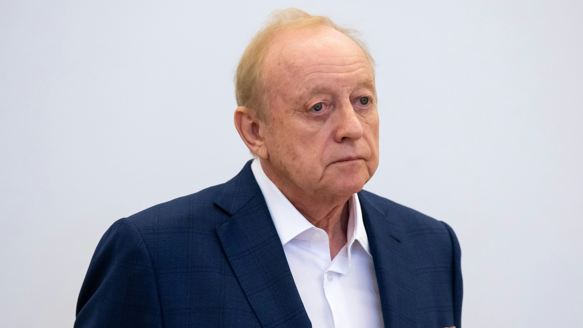 Alfons Schubeck steht in einem weißen Hemd und dunkelblauem Jackett im Gerichtssaal in München.
