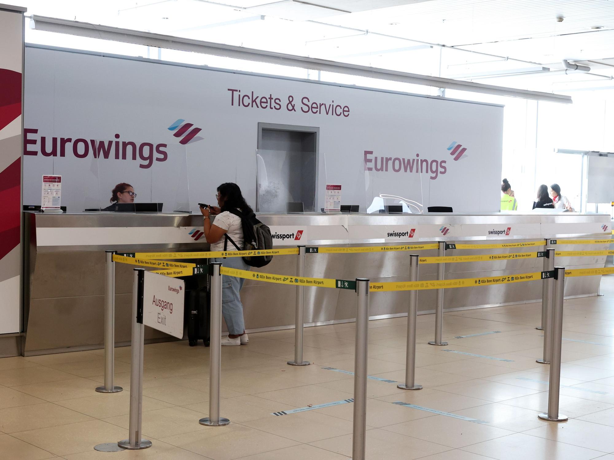 Eine Frau steht am Flughafen Köln/Bonn am Schalter von Eurowings.