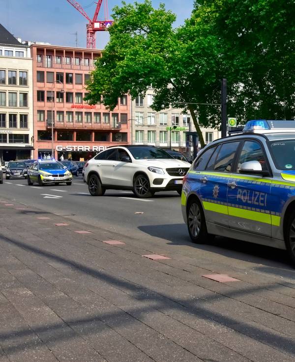 Ein Streifenwagen fährt in Köln am Neumarkt vorbei.