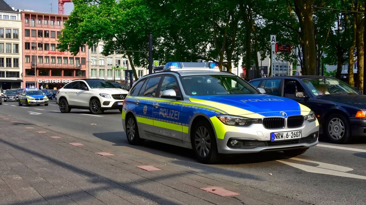 Ein Streifenwagen fährt in Köln am Neumarkt vorbei.