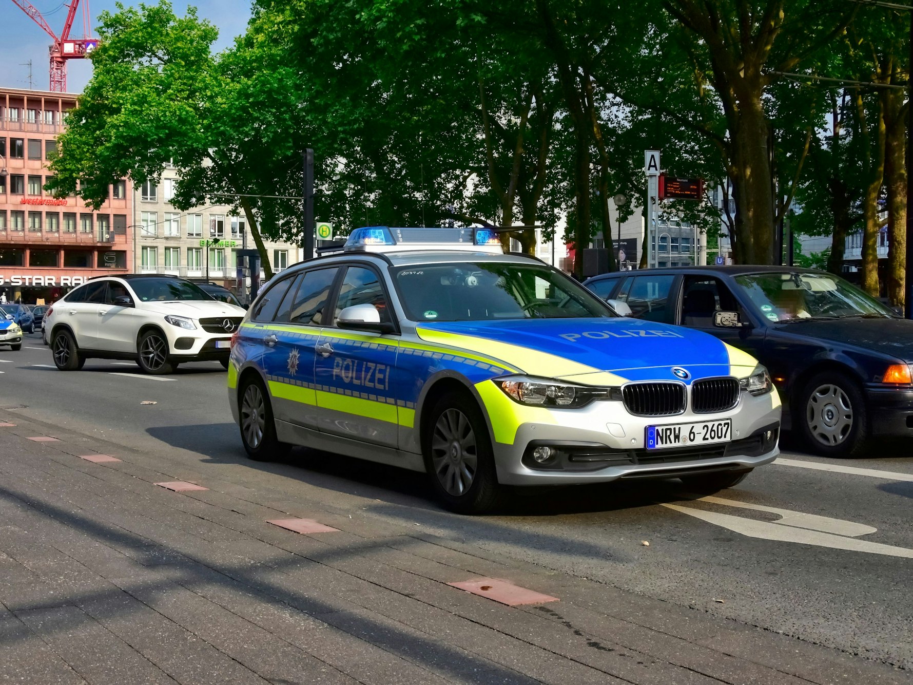 Ein Streifenwagen fährt in Köln am Neumarkt vorbei.