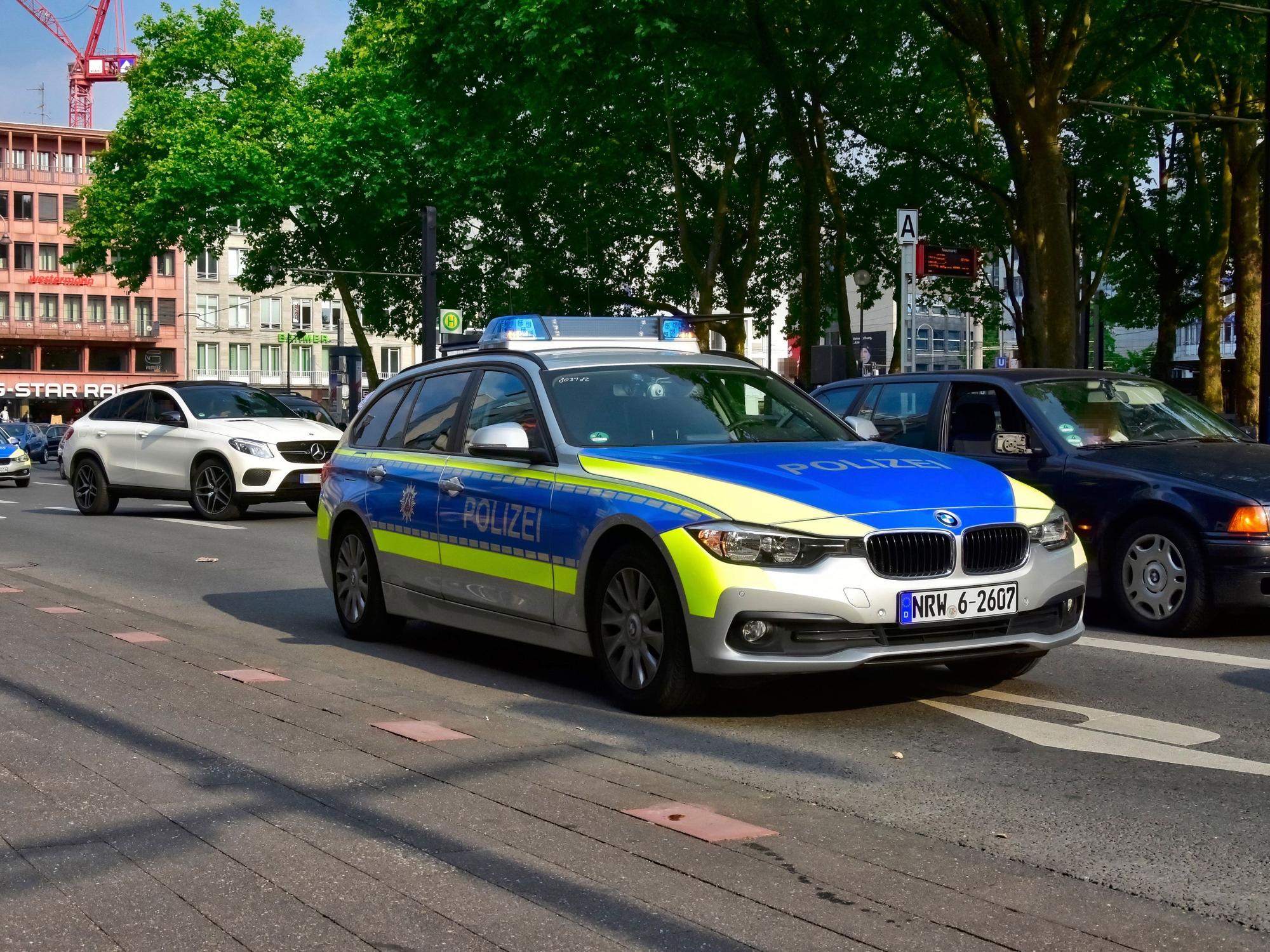 Ein Streifenwagen fährt in Köln am Neumarkt vorbei.
