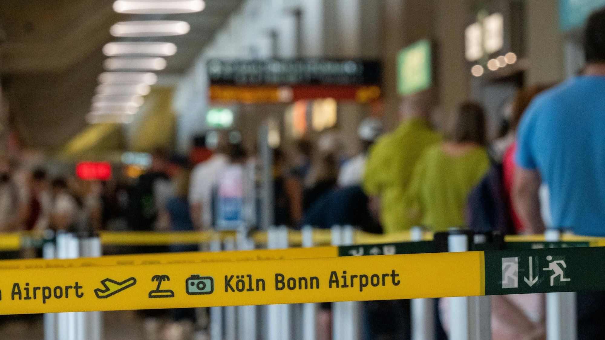 Am Flughafen Köln-Bonn warten viele Reisende vor der Sicherheitskontrolle.