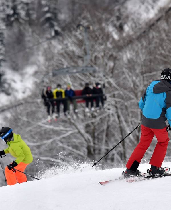 Das Symbolfoto zeigt zwei Personen mit Ski-Ausrüstung, die einen schneebedeckten Abhang hinunterfahren.