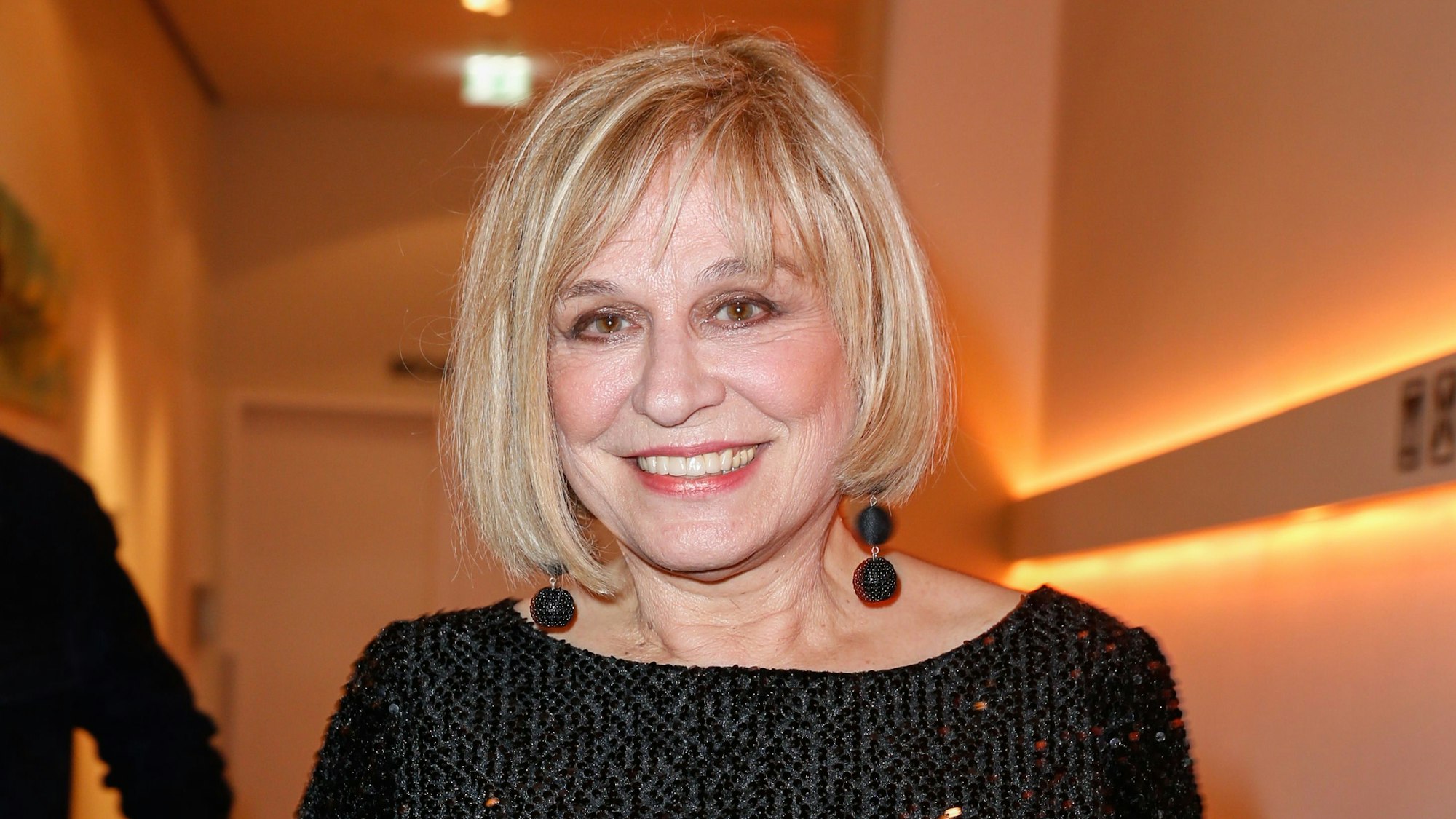 Mary Roos posiert in einem schwarzen Abendkleid für die Kmaeras.