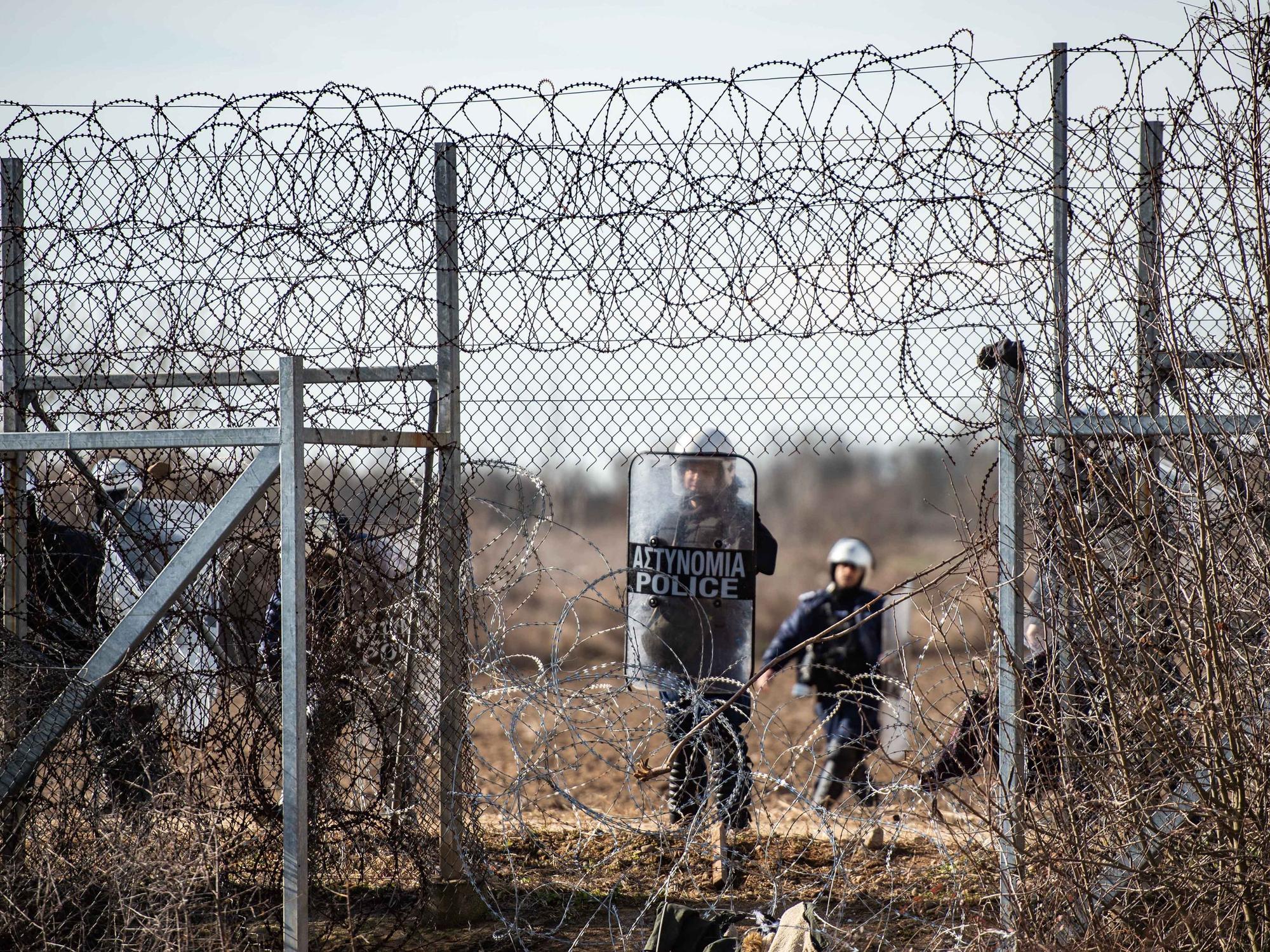 Ein griechischer Polizist steht an einem Loch im Zaun an der griechisch-türkischen Grenze. Auf der türkischen Seite der Grenze warten angeblich rund 12 500 Menschen auf die Möglichkeit, die Grenze zu überwinden. +++ dpa-Bildfunk +++
