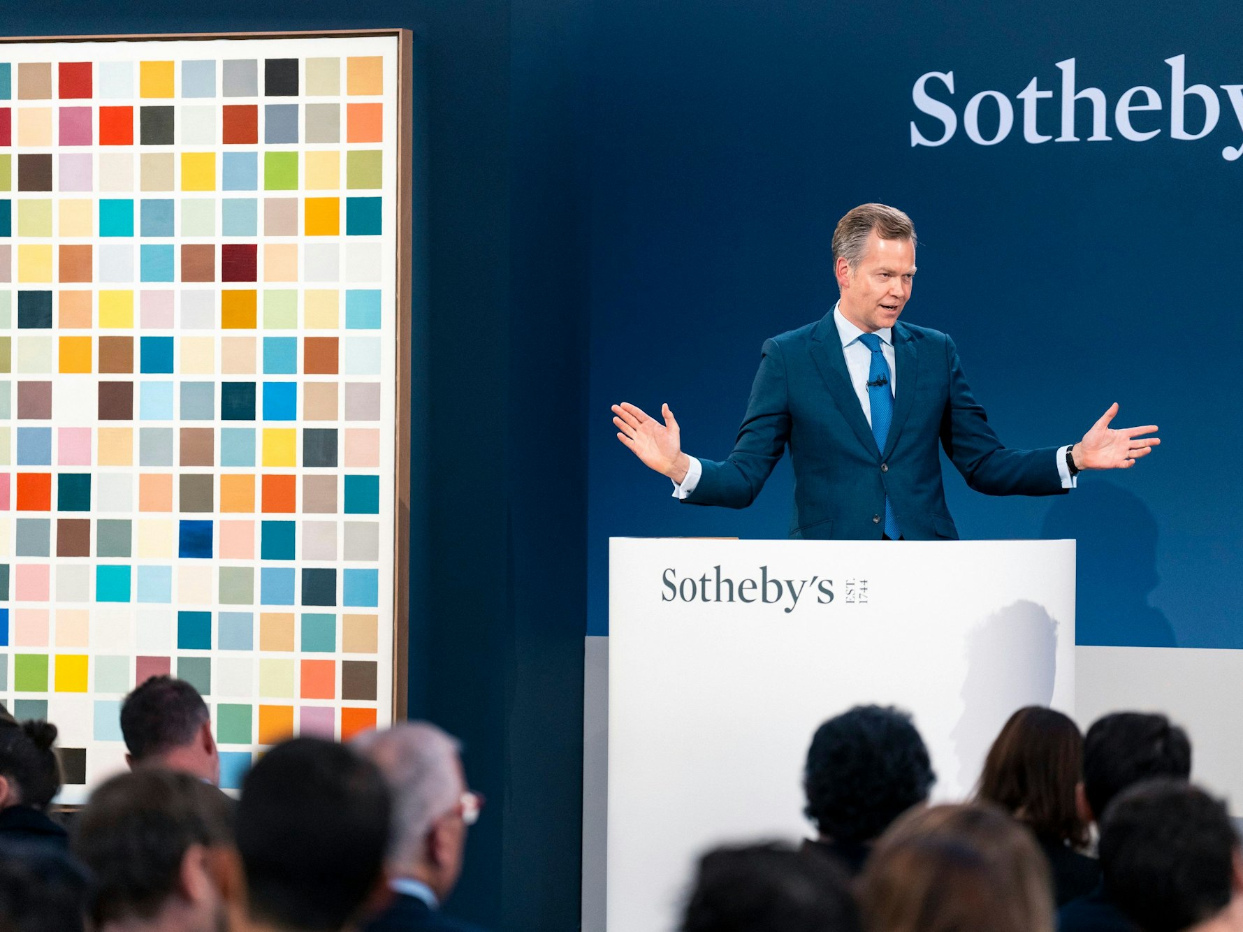 Ein Moderator bei einer Versteigerung bietet das Werk 192 Farben von Gerhard Richter an.