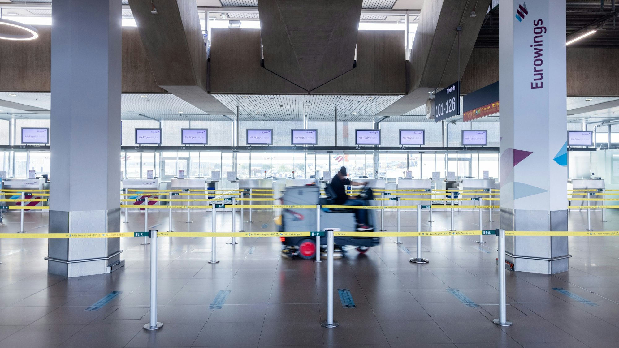 Eine Reinigungsmaschine wird durch den leeren Check In-Bereich von Eurowings am Flughafen Köln/Bonn gefahren.