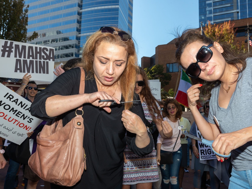 Zwei Frauen schneiden sich als Zeichen der Solidarität Haare ab.