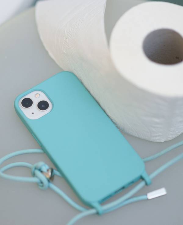 Ein Smartphone und eine Klopapierrolle liegen neben einer Toilette auf einem Badeimer.
