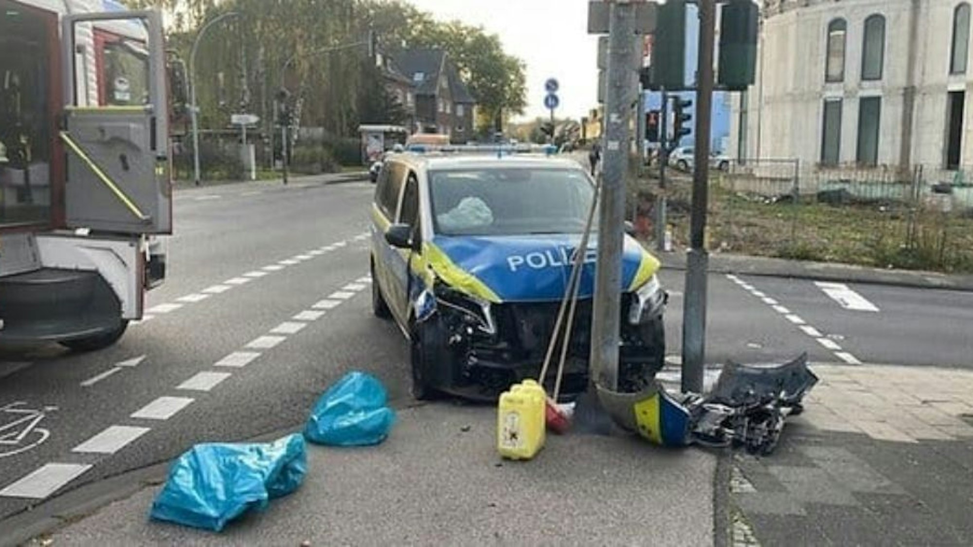 Ein stark beschädigtes Polizeifahrzeug steht vor einem Verkehrsmasten.