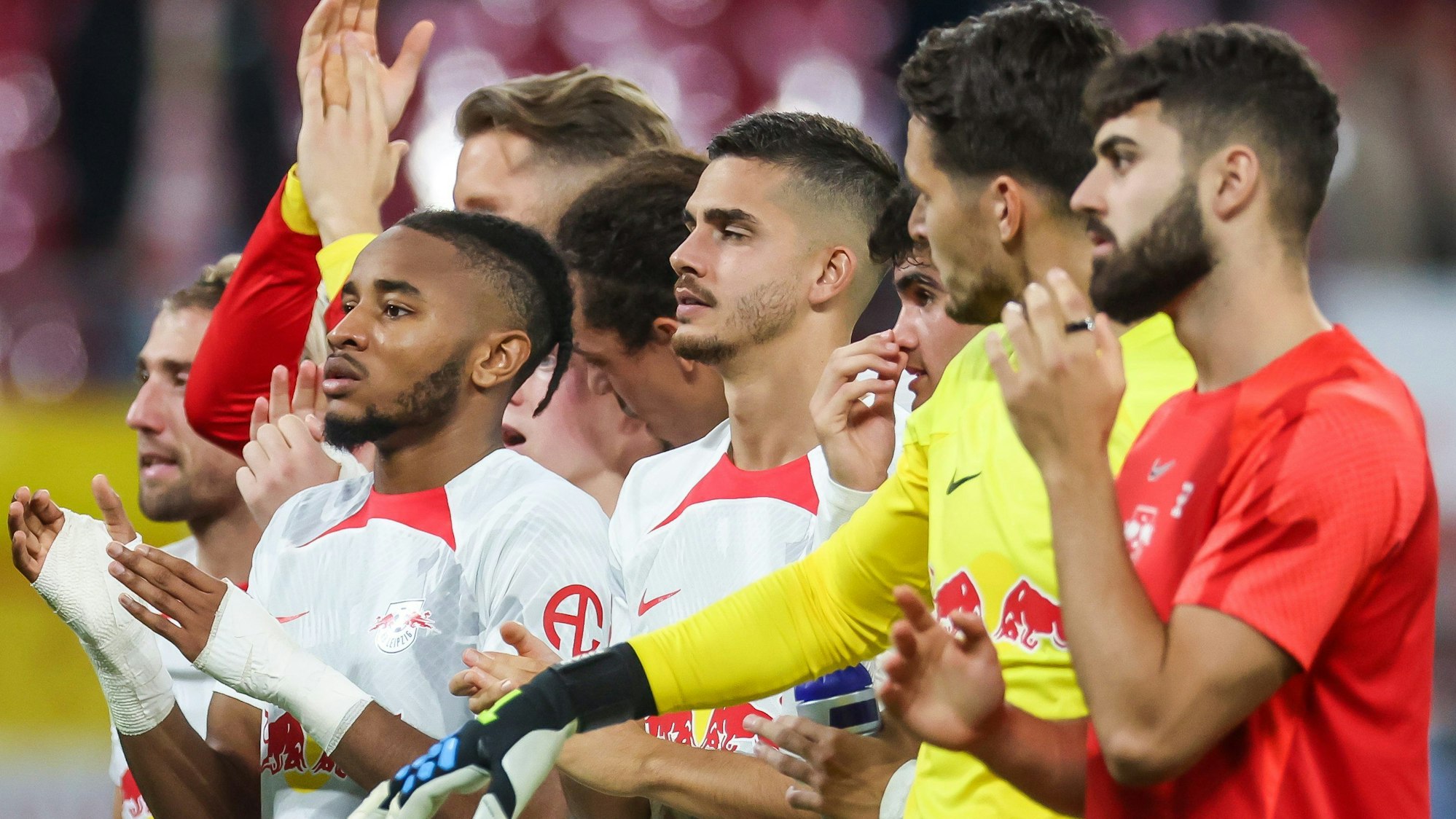 Leipzigs Spieler um Christopher Nkunku (beide Hände bandagiert) bedanken sich bei den Fans.
