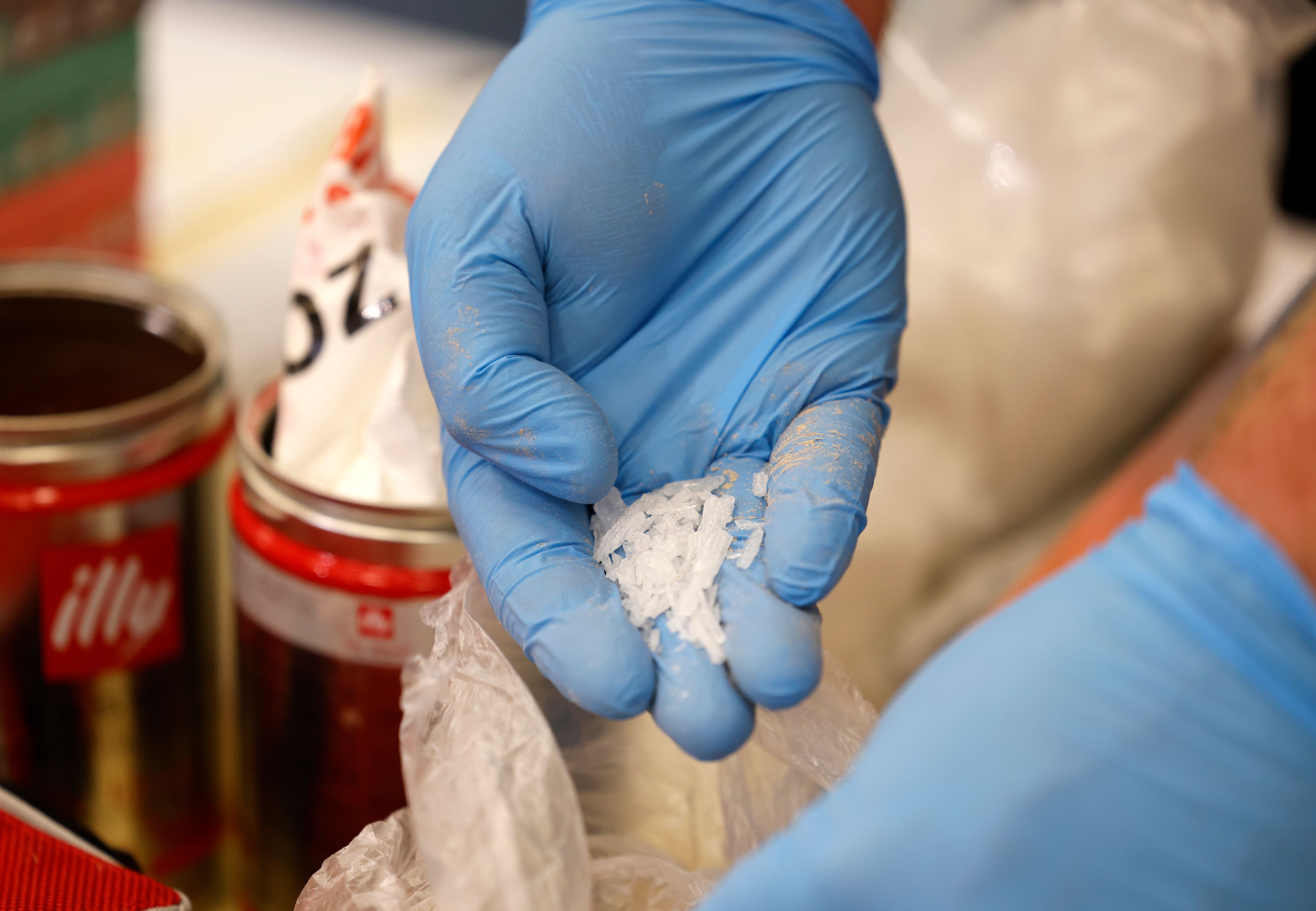 Das undatierte Symbolfoto zeigt zwei Hände in blauen Gummihandschuhen. In einer Hand liegt die Droge Crystal Meth.