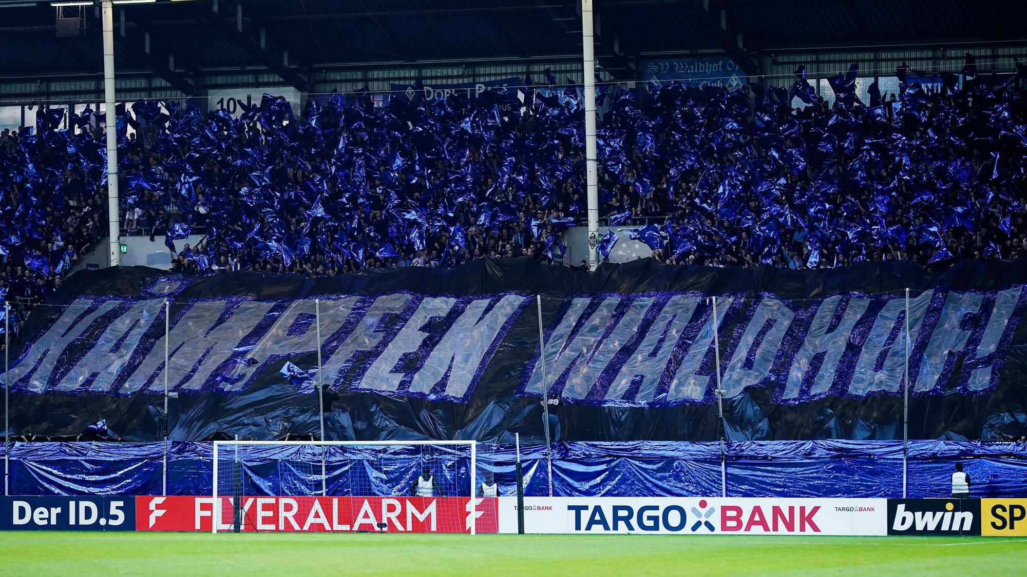 Die Fankurve von Waldhof Mannheim feuert ihr Team an.