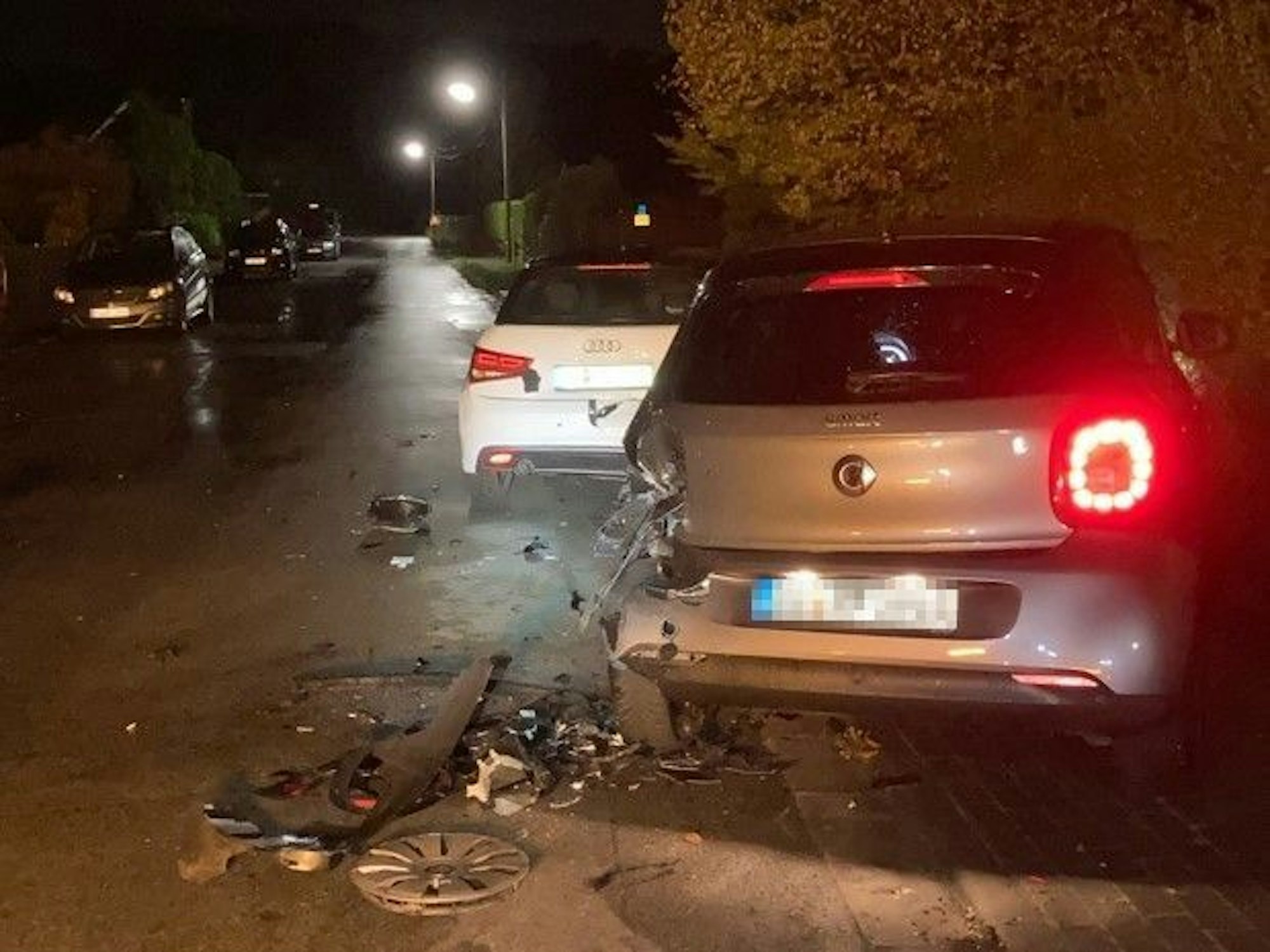 Ein lecht demolierter Audi und ein Smart mit Totalschaden stehen am Wegesrand.