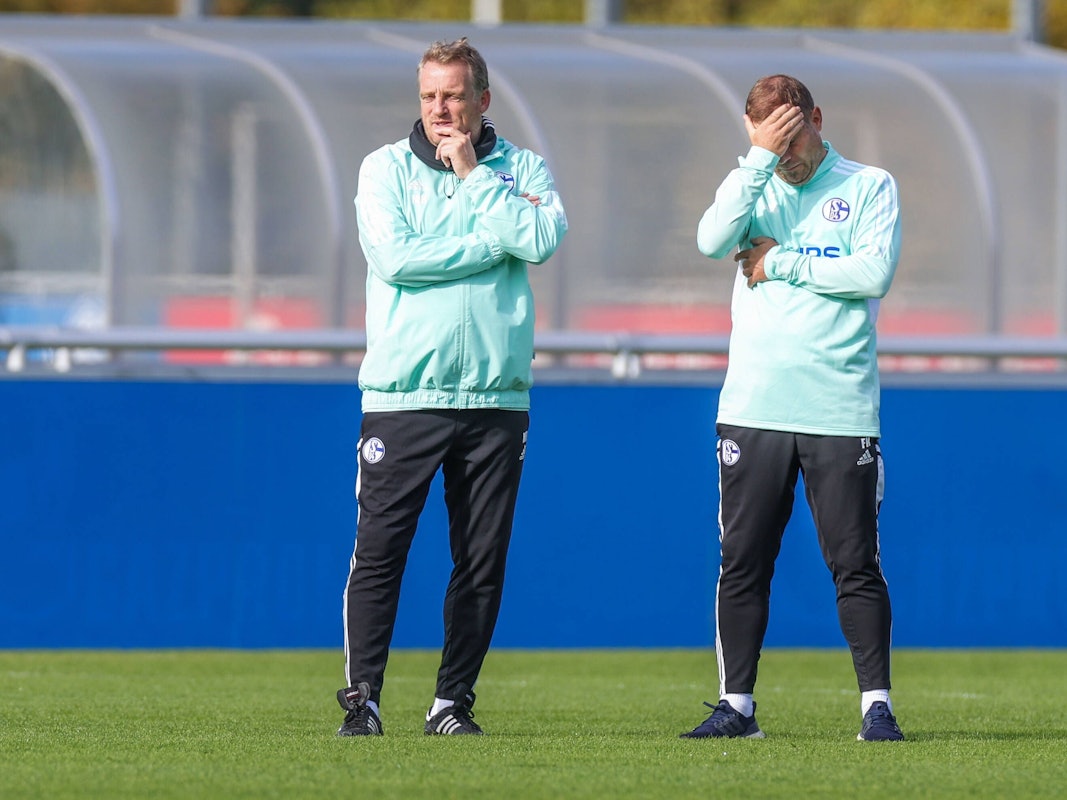 Co-Trainer Mike Büskens und Frank Kramer stehen auf dem Platz beim FC Schalke 04.