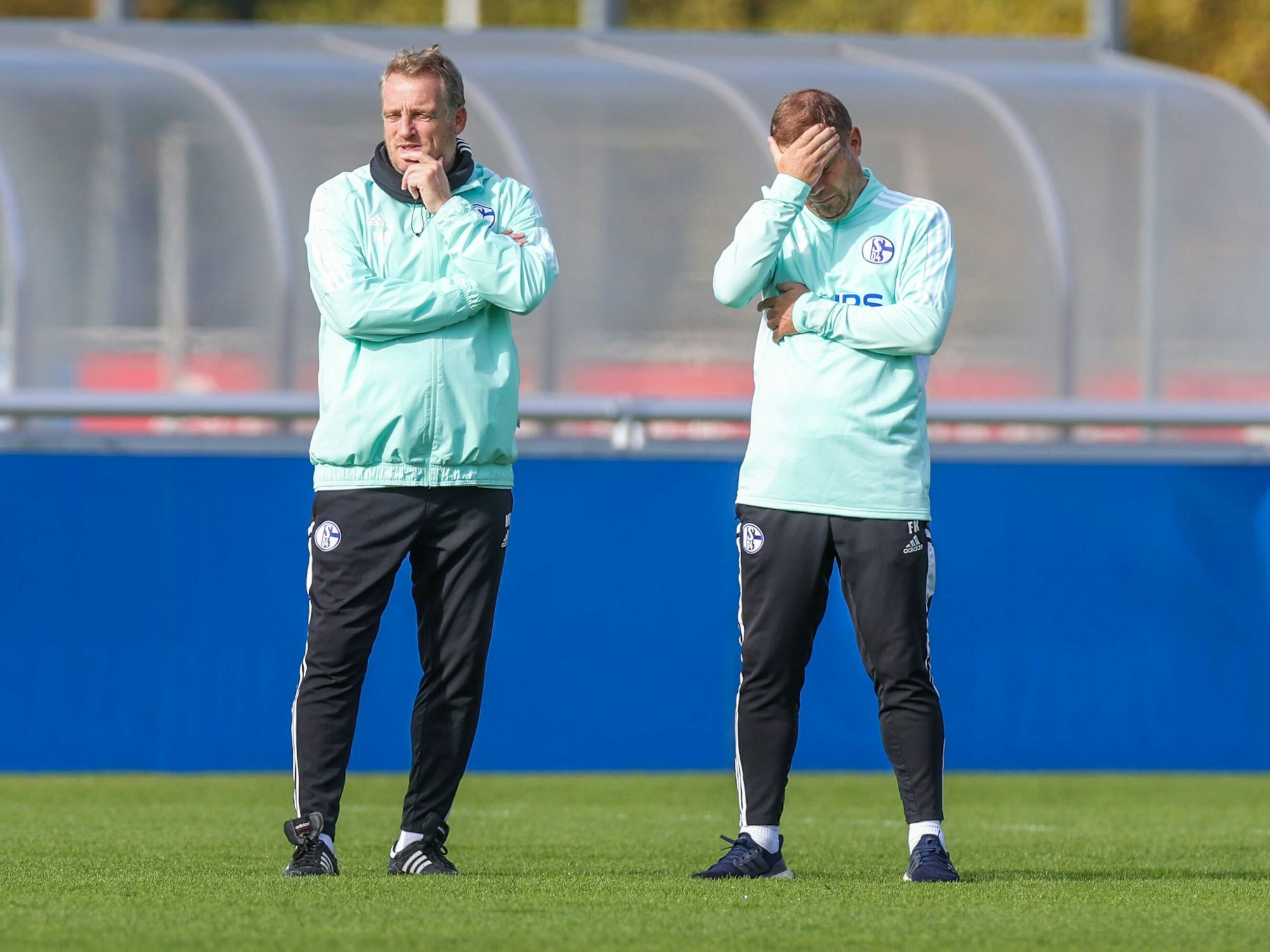 Co-Trainer Mike Büskens und Frank Kramer stehen auf dem Platz beim FC Schalke 04.