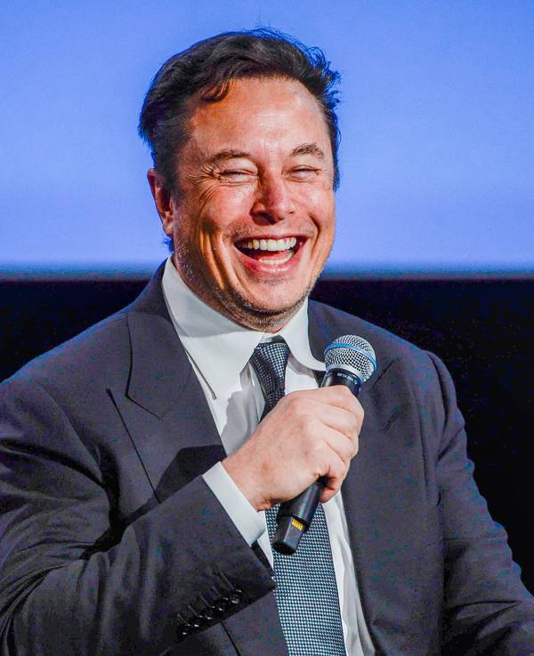 Elon Musk hält ein Mikro in der Hand.