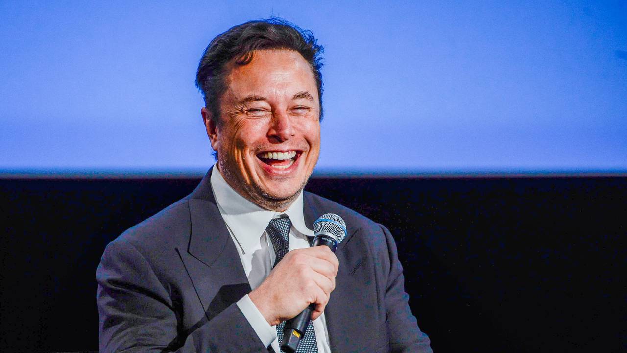 Elon Musk hält ein Mikro in der Hand.