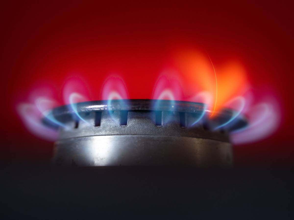 Die Flamme eines Gasherdes brennt in einer Küche.
