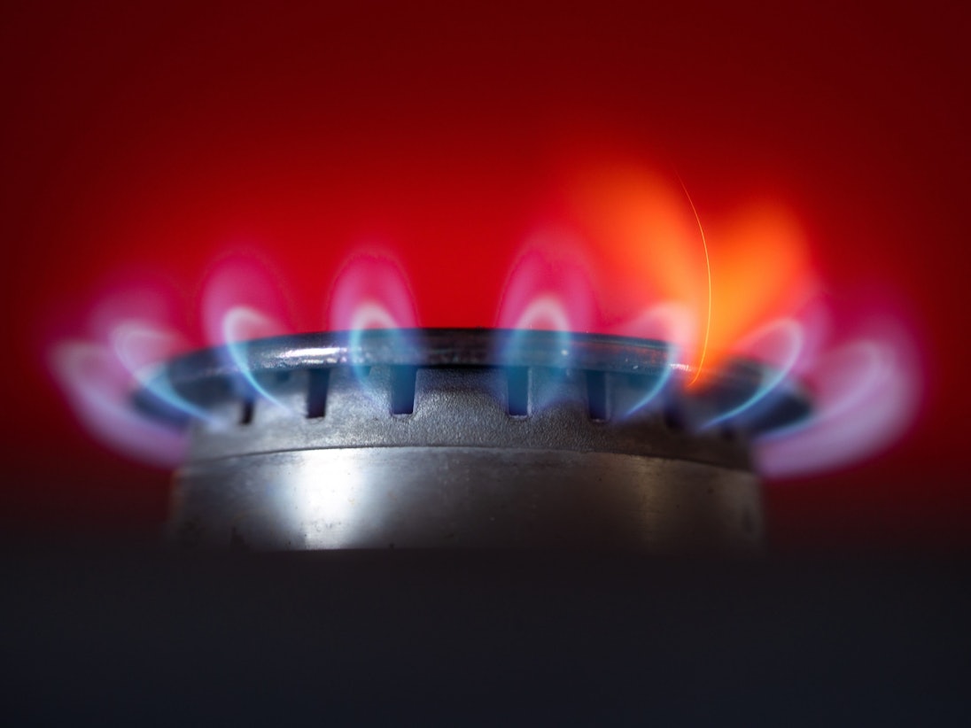 Die Flamme eines Gasherdes brennt in einer Küche.