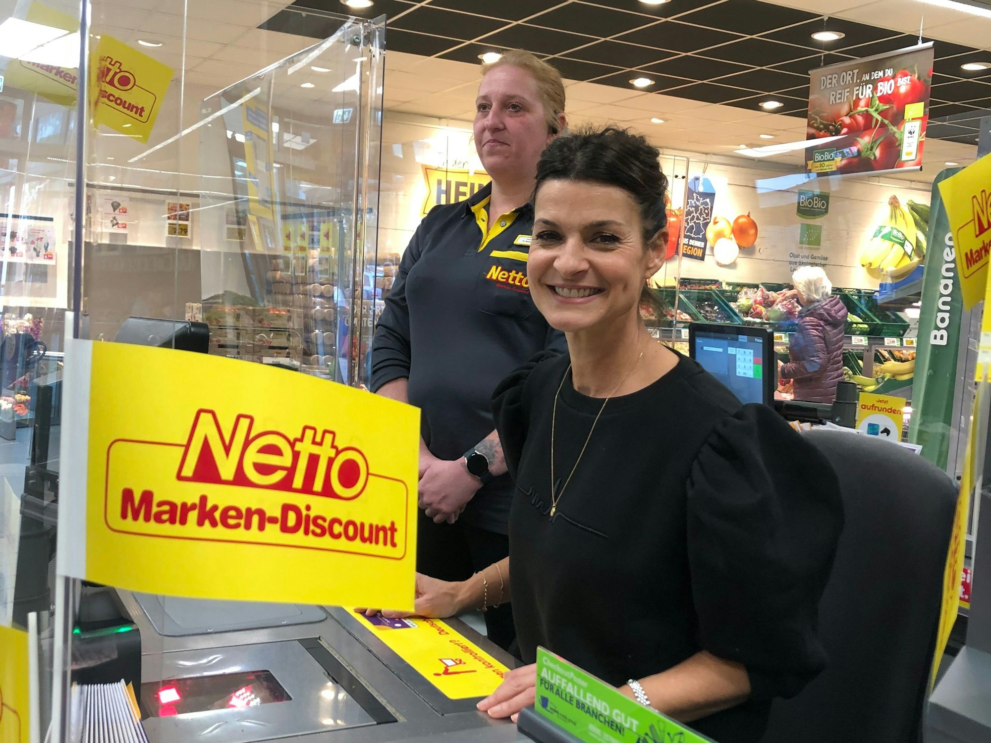 Die Sat.1-„Frühstücksfernsehen“-Moderatorin sitzt am 20. Oktober 2022 für den guten Zweck hinter einer Netto-Marken-Discount-Kasse.