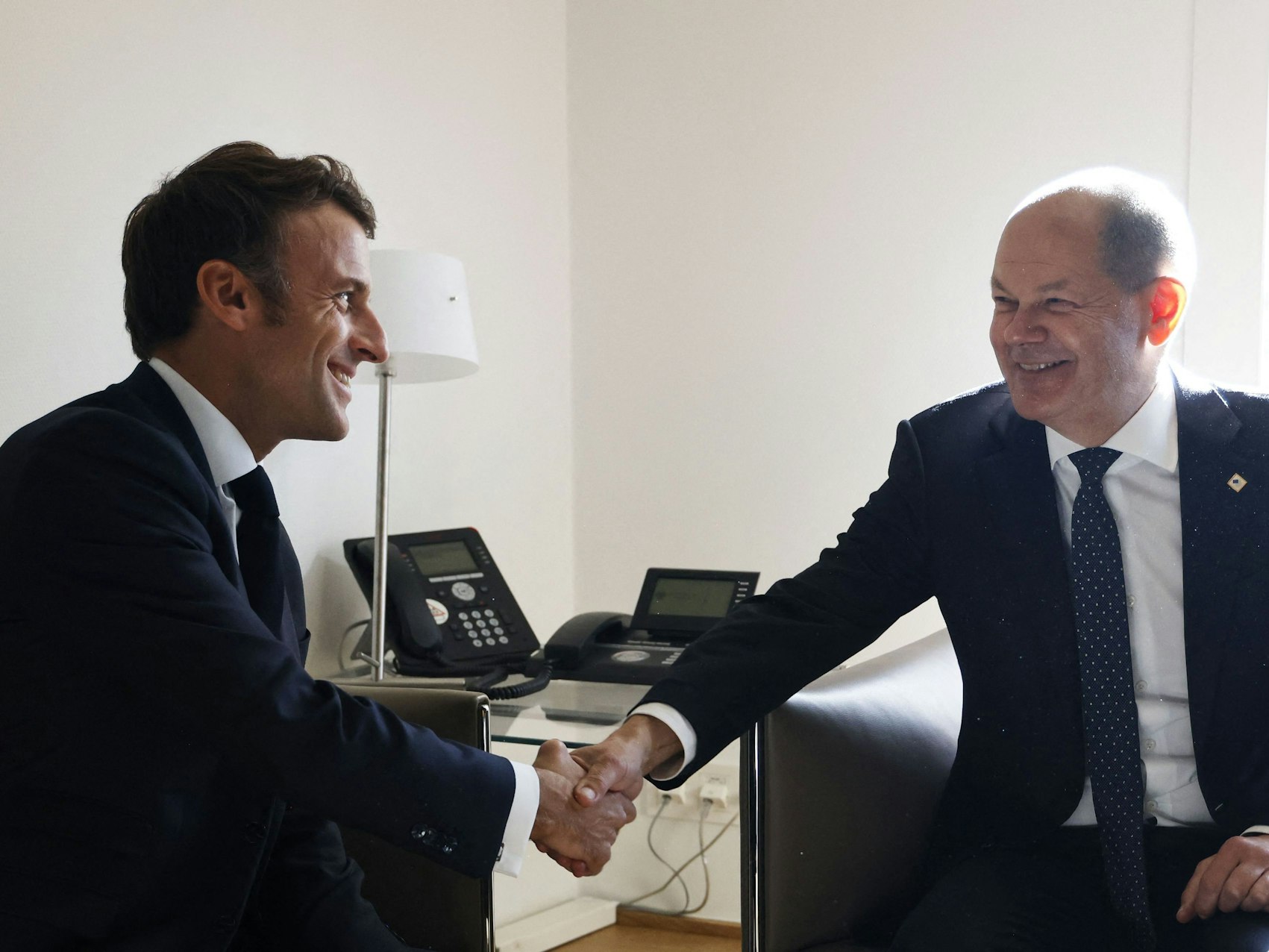 Emmanuel Macron (l.) und Olaf Scholz schütteln sich am 20. Oktober 2022 lächelnd die Hände. Doch zwischen den beiden Regierungschefs knirscht es.