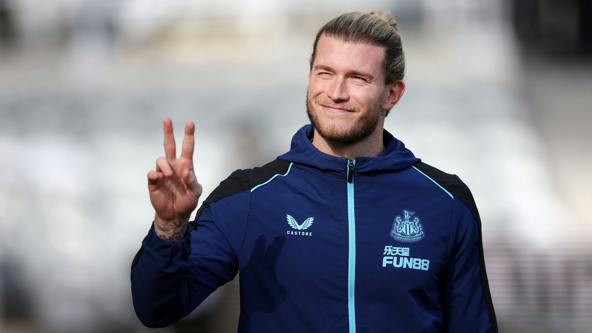 Loris Karius zeigt lachend das Peace-Zeichen.