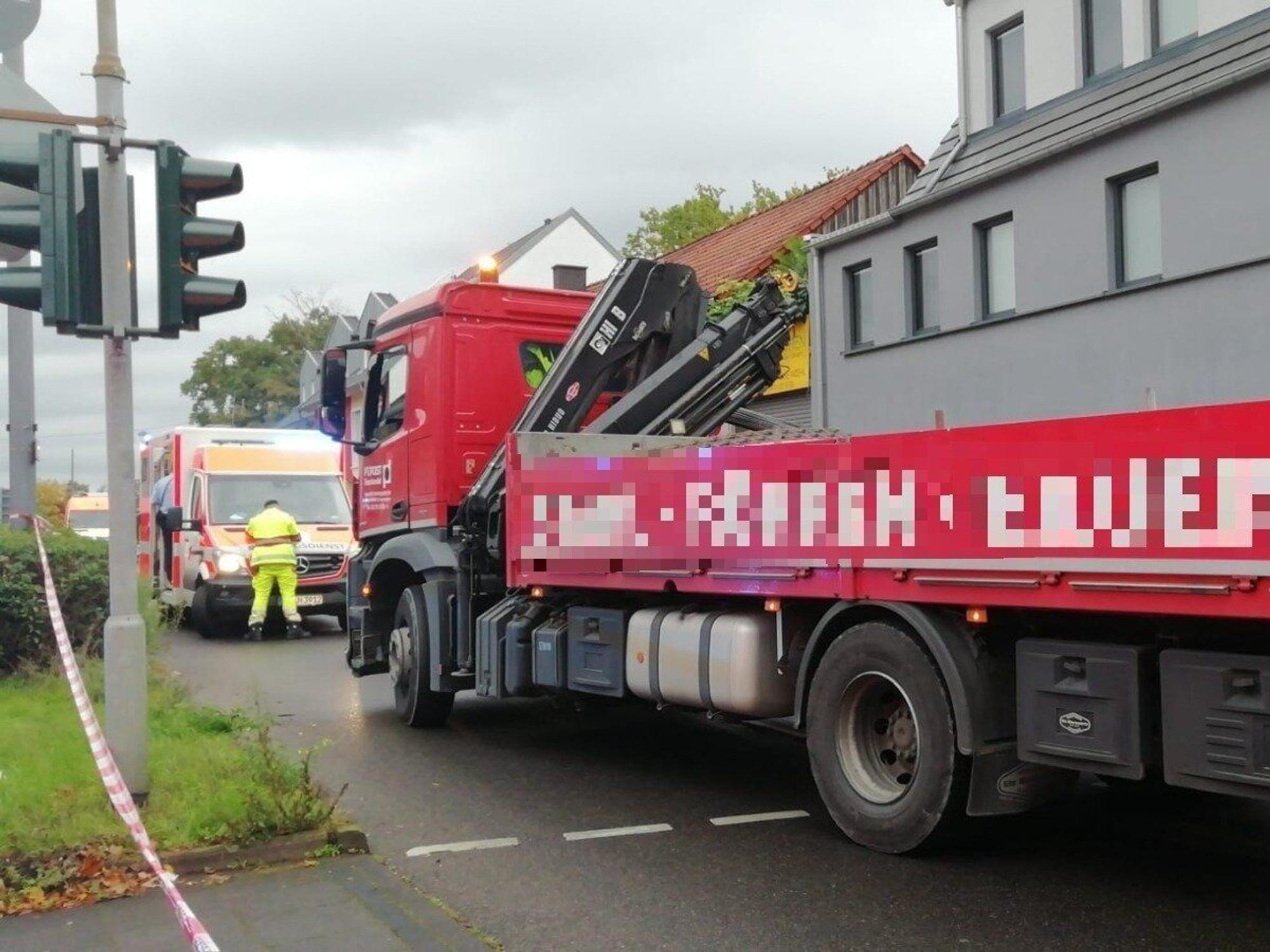 Ein Rettungswagen steht vor dem in den Unfall verwickelten Lkw.