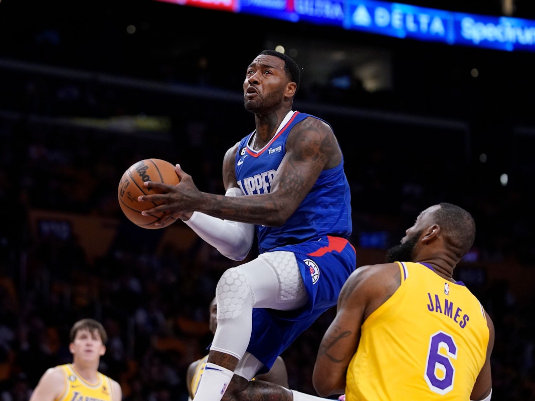 Clippers-Profi John Wall (l.) steigt hoch zum Korb, Lakers-Star Lebron James kann nur zugucken.