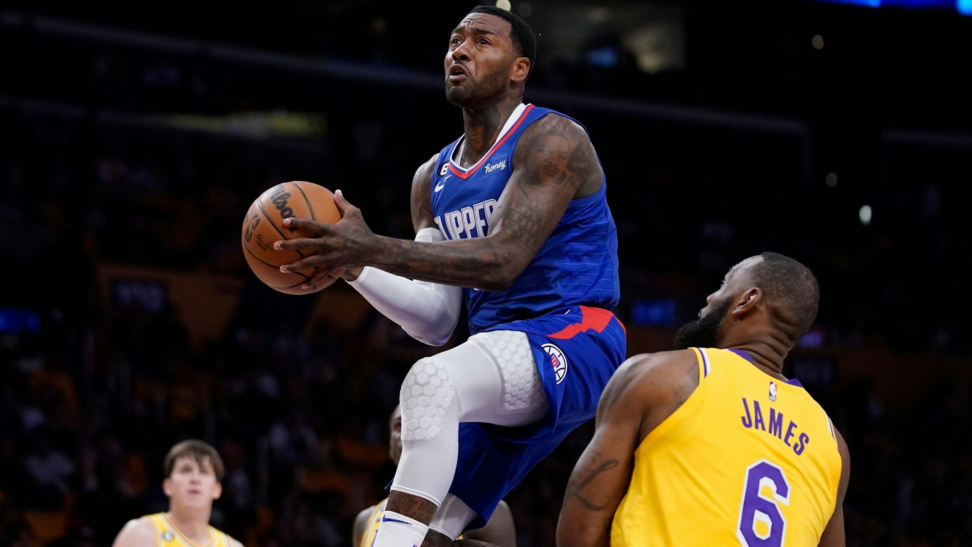 Clippers-Profi John Wall (l.) steigt hoch zum Korb, Lakers-Star Lebron James kann nur zugucken.