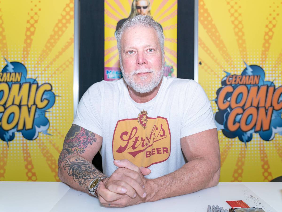 Kevin Nash sitzt bei einem Termin Dortmund am Tisch.