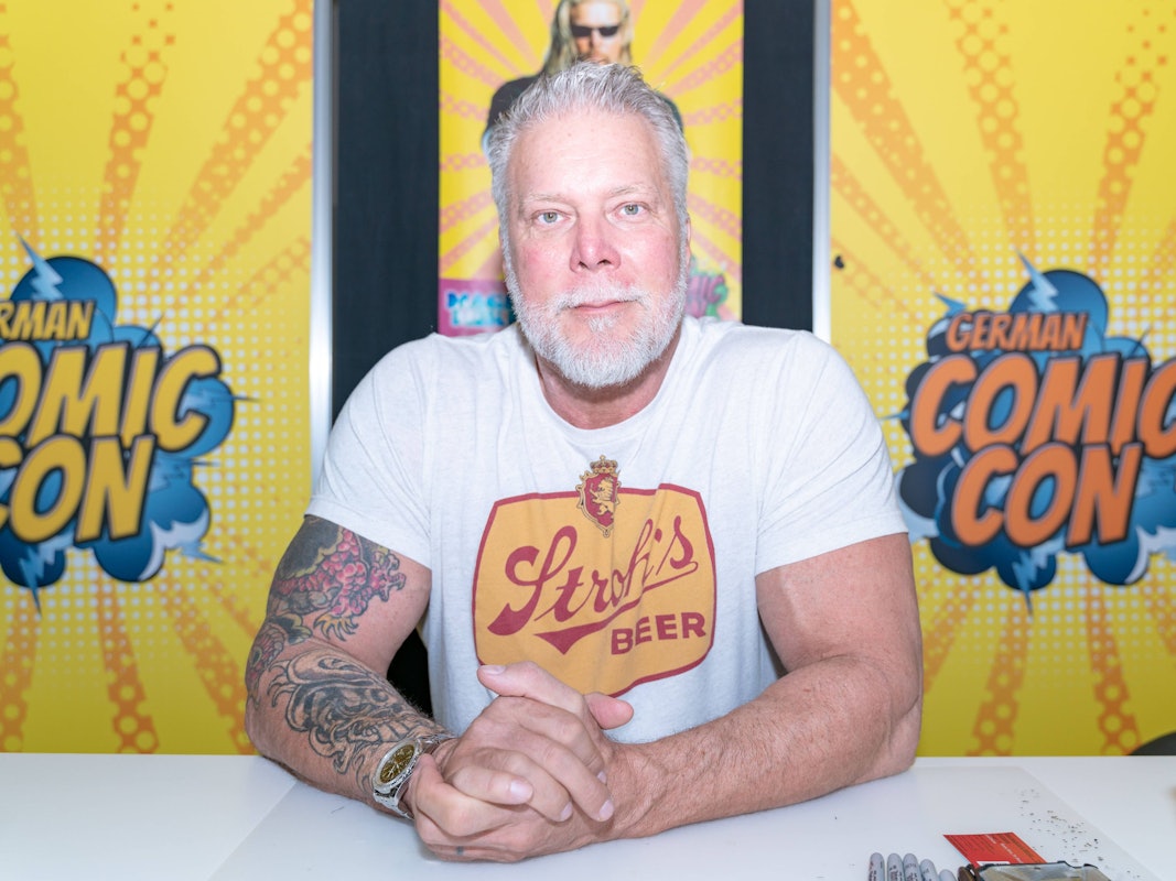 Kevin Nash sitzt bei einem Termin Dortmund am Tisch.