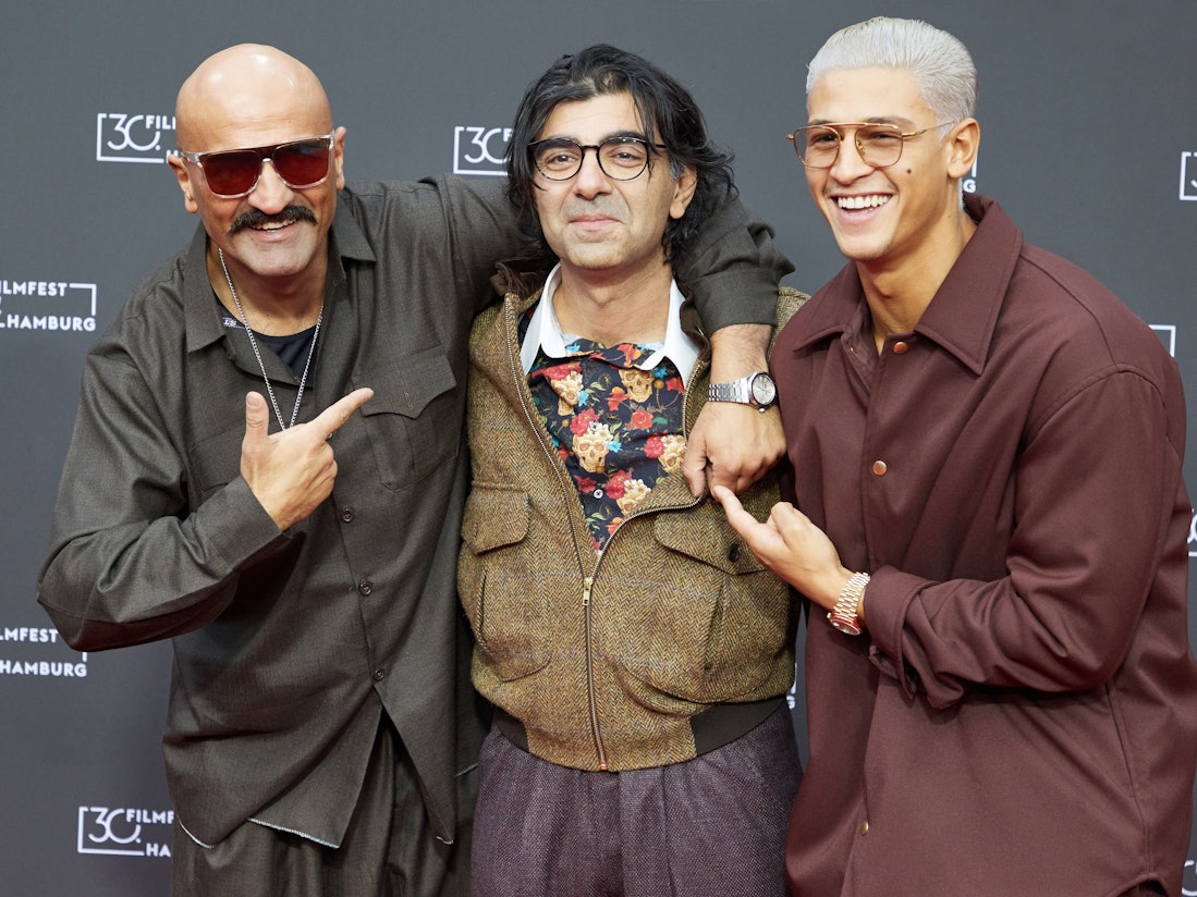 Der Rapper Xatar, mit bürgerlichem Namen Giwar Hajabi (l.), Fatih Akin, Regisseur, und Emilio Sakraya (r.), Schauspieler, stehen auf dem Roten Teppich zu ihrem Film „Rheingold“ vor einem Hamburger Kino im Oktober 2022.