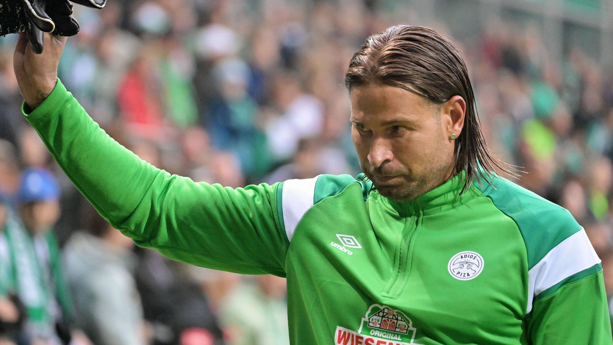 Tim Wiese winkt den Fans. Er trägt einen grünen Trainingsanzug.