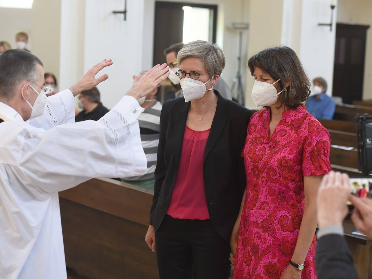 Bayern, München: Pfarrvikar Wolfgang Rothe segnet das Paar Christine Walter (links) und Almut Münster bei einem katholischen Gottesdienst mit Segnung homosexueller Paare im Rahmen einer bundesweiten Aktion in der Kirche St. Benedikt. Die Aufnahme ist vom 9. Mai 2021.