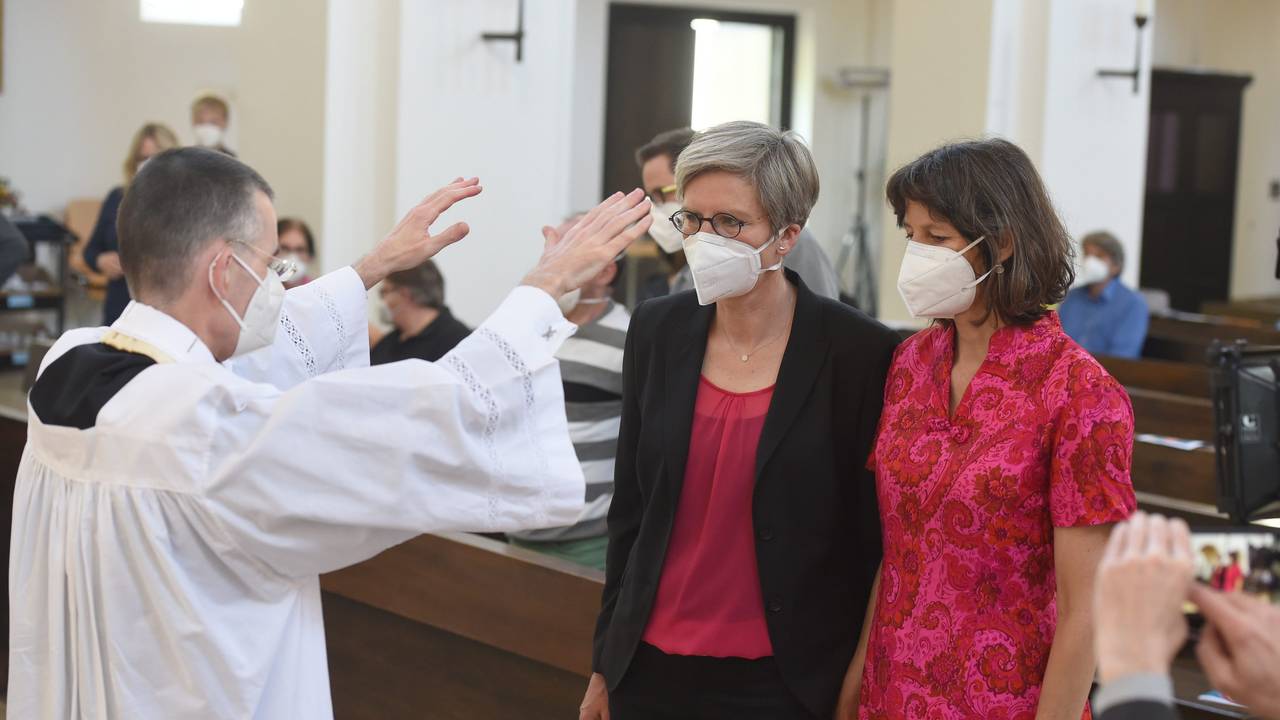 Bayern, München: Pfarrvikar Wolfgang Rothe segnet das Paar Christine Walter (links) und Almut Münster bei einem katholischen Gottesdienst mit Segnung homosexueller Paare im Rahmen einer bundesweiten Aktion in der Kirche St. Benedikt. Die Aufnahme ist vom 9. Mai 2021.